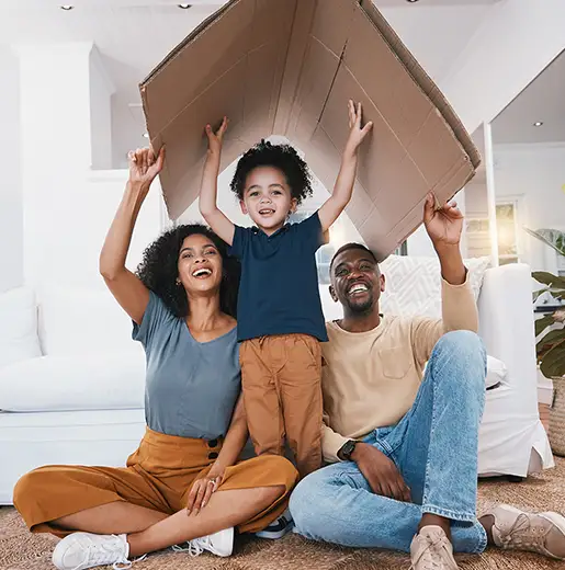 family having fun while moving making a cardboard house