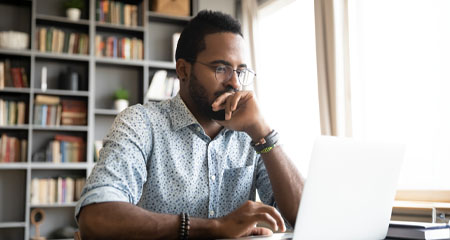 Man looking at laptop on desk